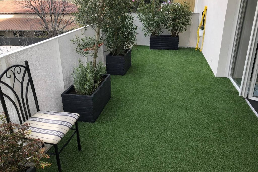 Pose de gazon synthétique sur un balcon à Mauguio avec jardinières et plantations